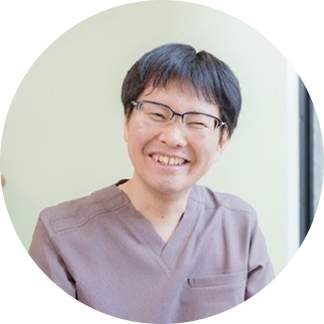 院長 村松慎一郎のポートレート。スクラブ姿で微笑んでいる様子。